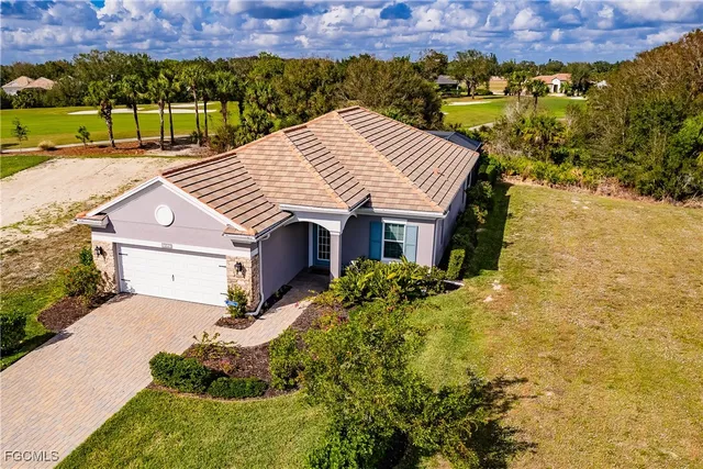 a aerial view of a house with a yard and a large tree