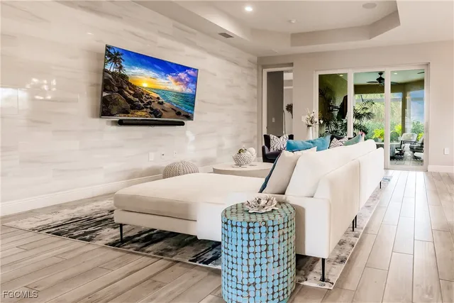 a living room with furniture a flat screen tv and a large window