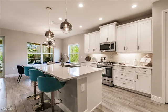 a kitchen with granite countertop a center island a counter space stainless steel appliances and cabinets