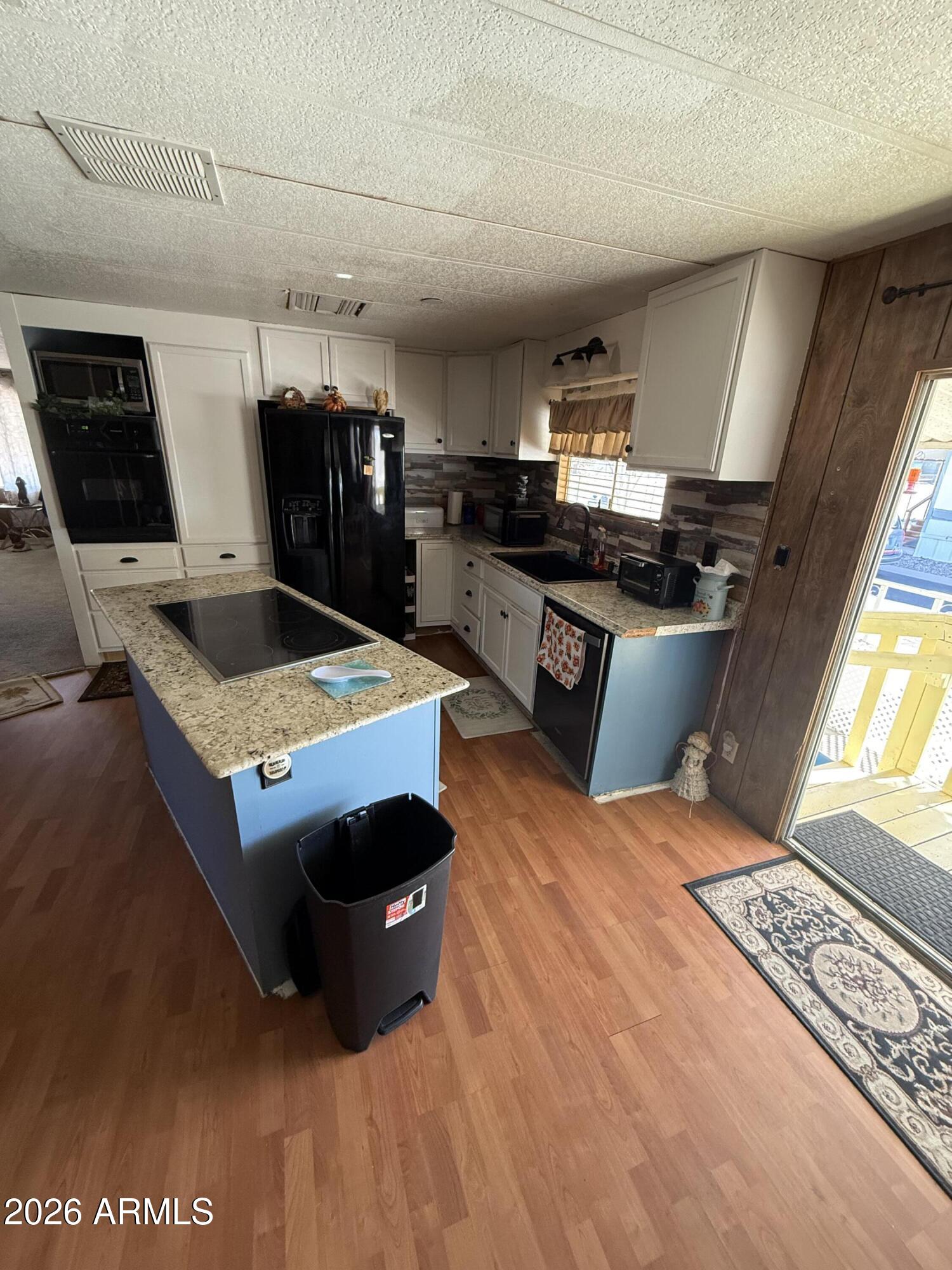 9501 East Broadway Road, Unit 252 Mesa, AZ 85208 - Photo 16 of 31 a living room with furniture a flat screen tv and kitchen view