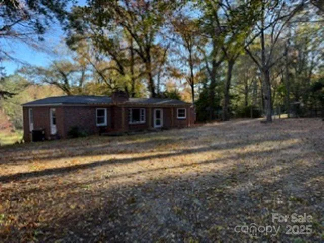 a view of a house with a yard and large tree