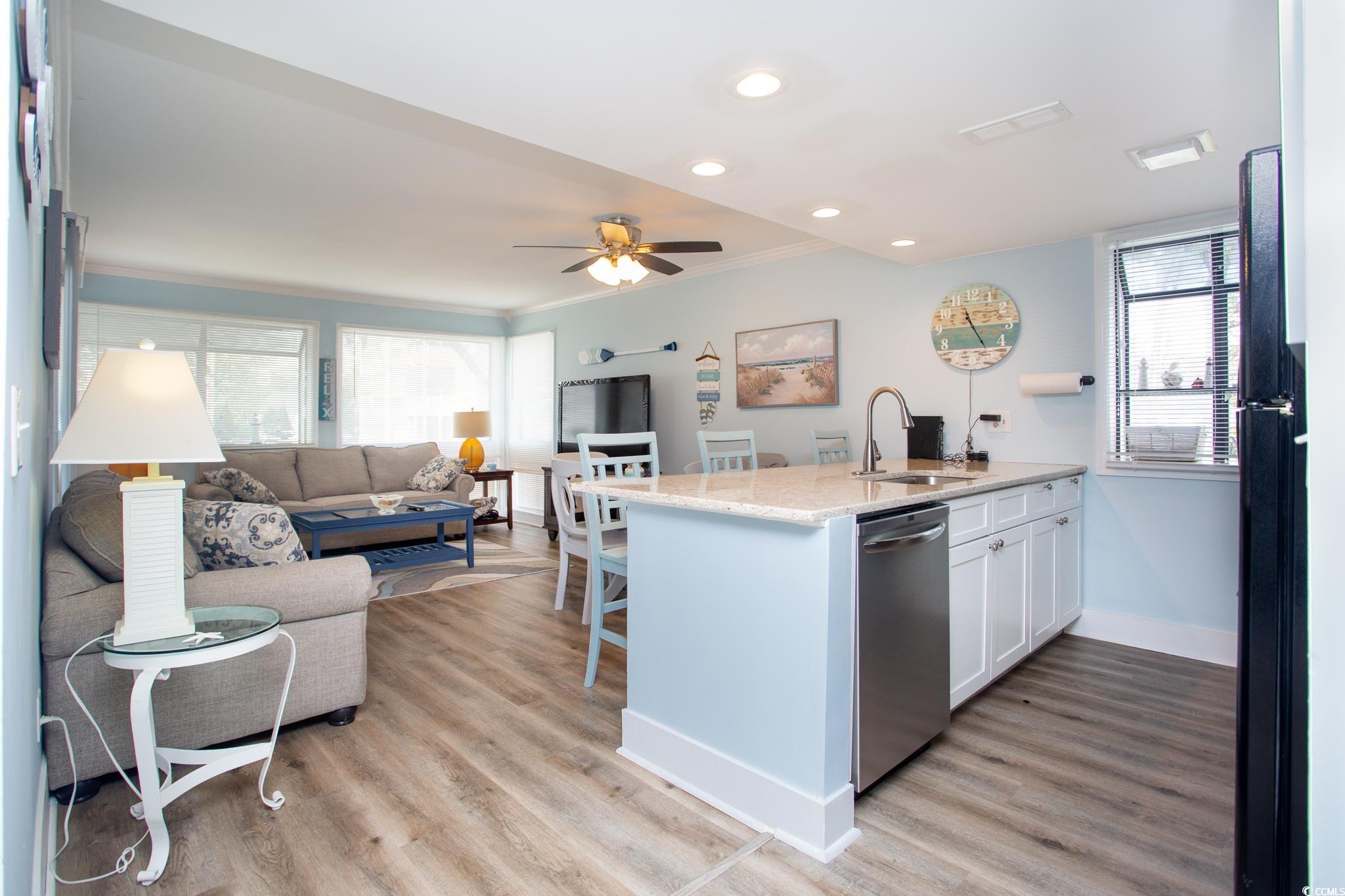 Kitchen featuring a healthy amount of sunlight, dishwasher, sink, and white cabinets