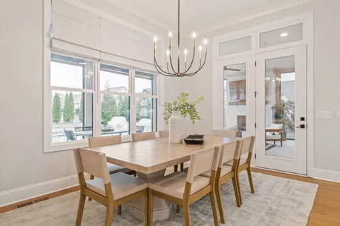 a dining room with furniture a chandelier and wooden floor