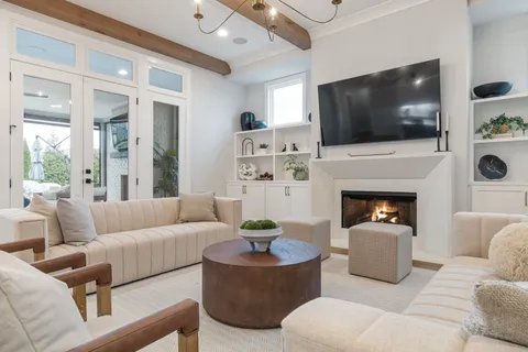 a living room with furniture a flat screen tv and kitchen view