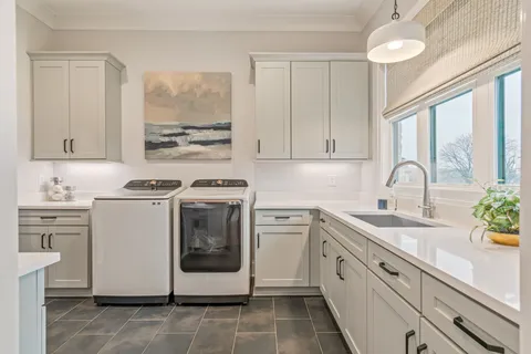 a white kitchen with sink and cabinets