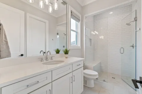 a bathroom with a sink a toilet and shower