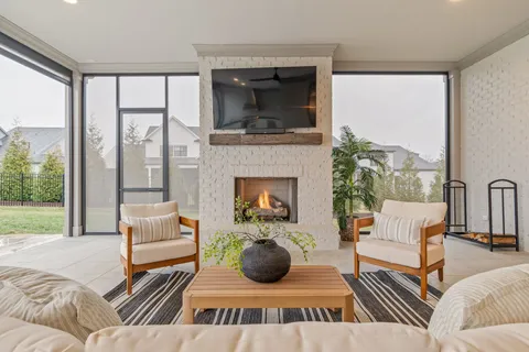 a living room with furniture a flat screen tv and a fireplace