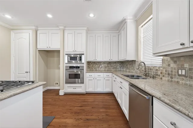 a kitchen with a stove top oven and white cabinets
