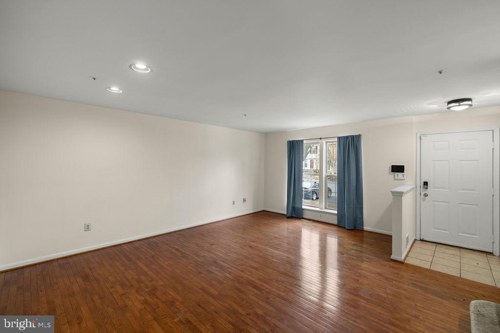9823 Sherwood Farm Road Owings Mills, MD 21117 - Photo 4 of 29 a view of an empty room with wooden floor and a window