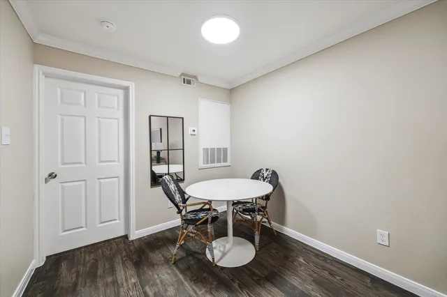 a view of a room with wooden floor table and chairs