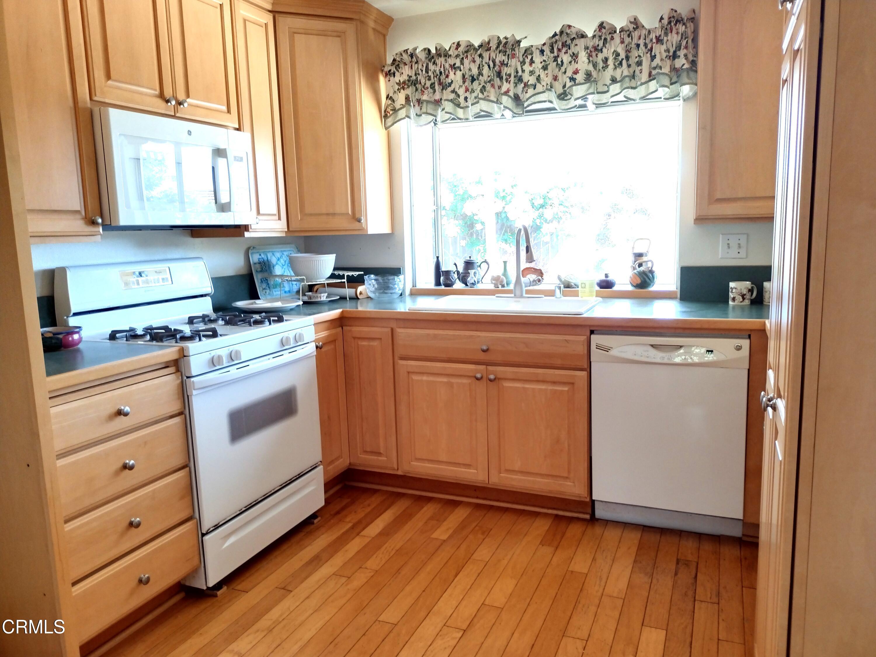 5928 Palomar Circle Camarillo, CA 93012 - Photo 8 of 33 a kitchen with granite countertop white cabinets and white appliances