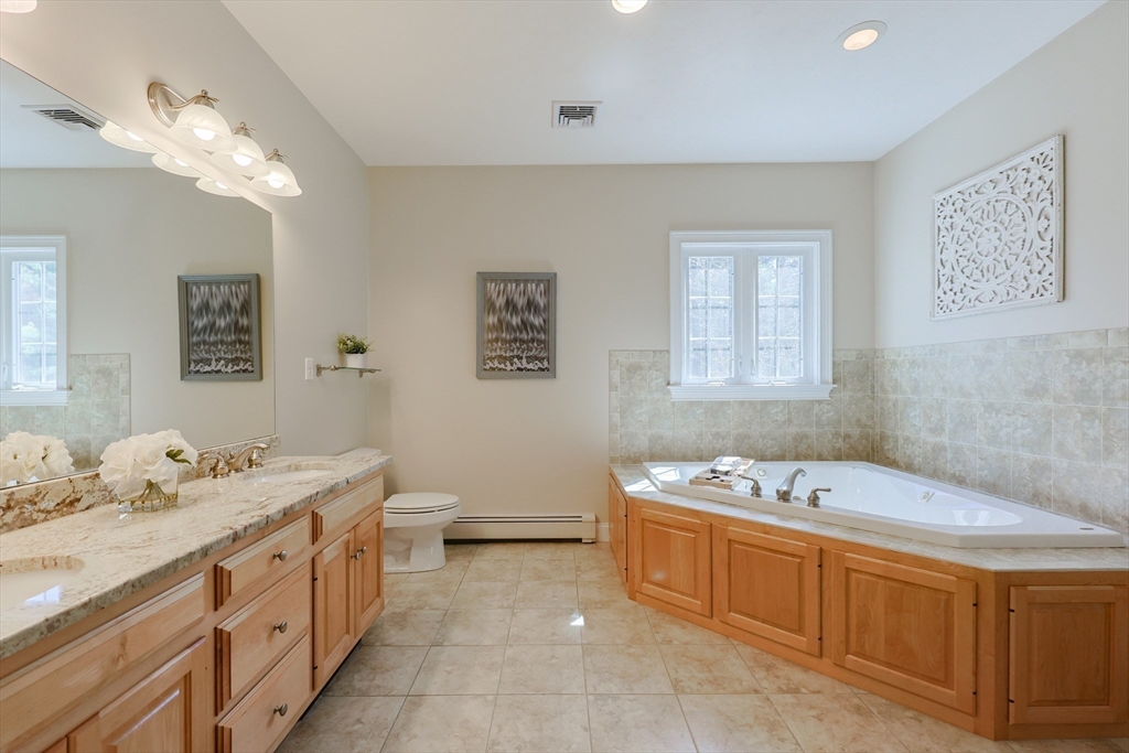 4 Berkeley Drive Walpole, MA 02081 - Photo 25 of 42 a spacious bathroom with a granite countertop sink a large mirror and a bathtub