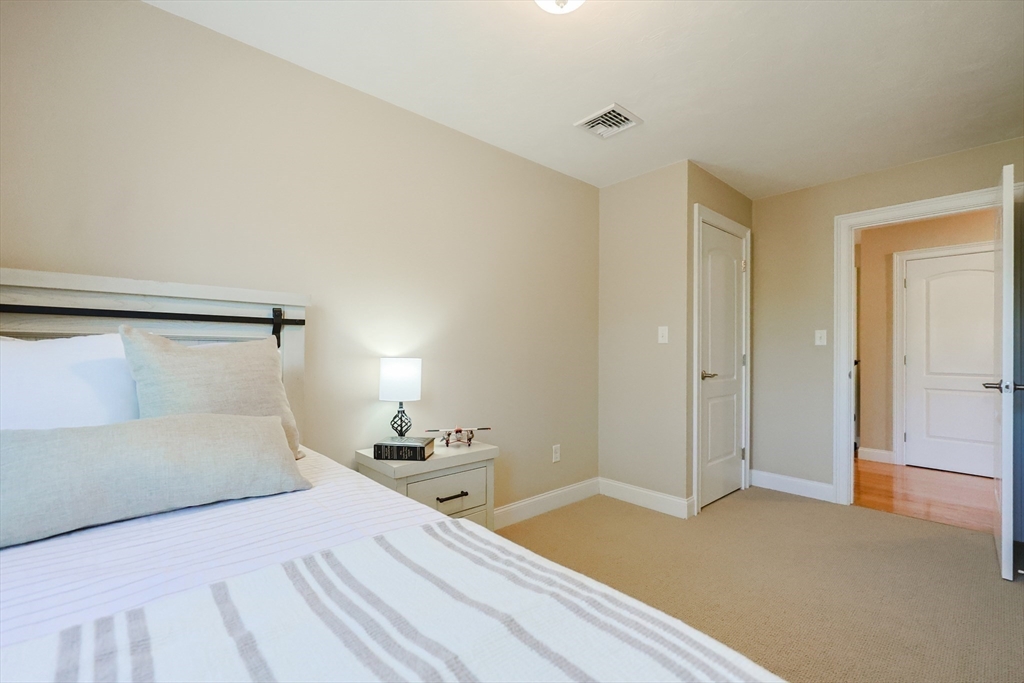 4 Berkeley Drive Walpole, MA 02081 - Photo 29 of 42 a bedroom with a bed and a mirror