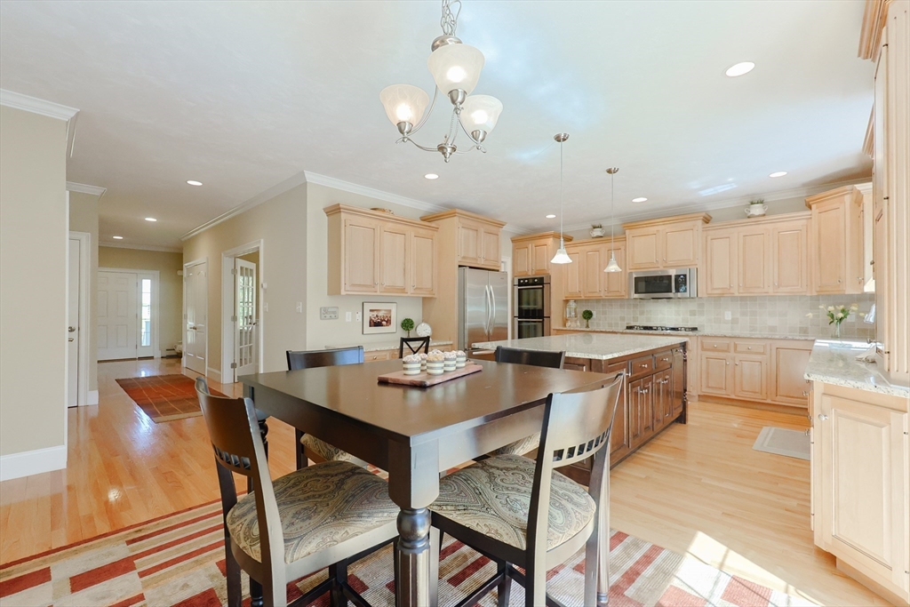 4 Berkeley Drive Walpole, MA 02081 - Photo 6 of 42 a kitchen with a dining table chairs stainless steel appliances and cabinets