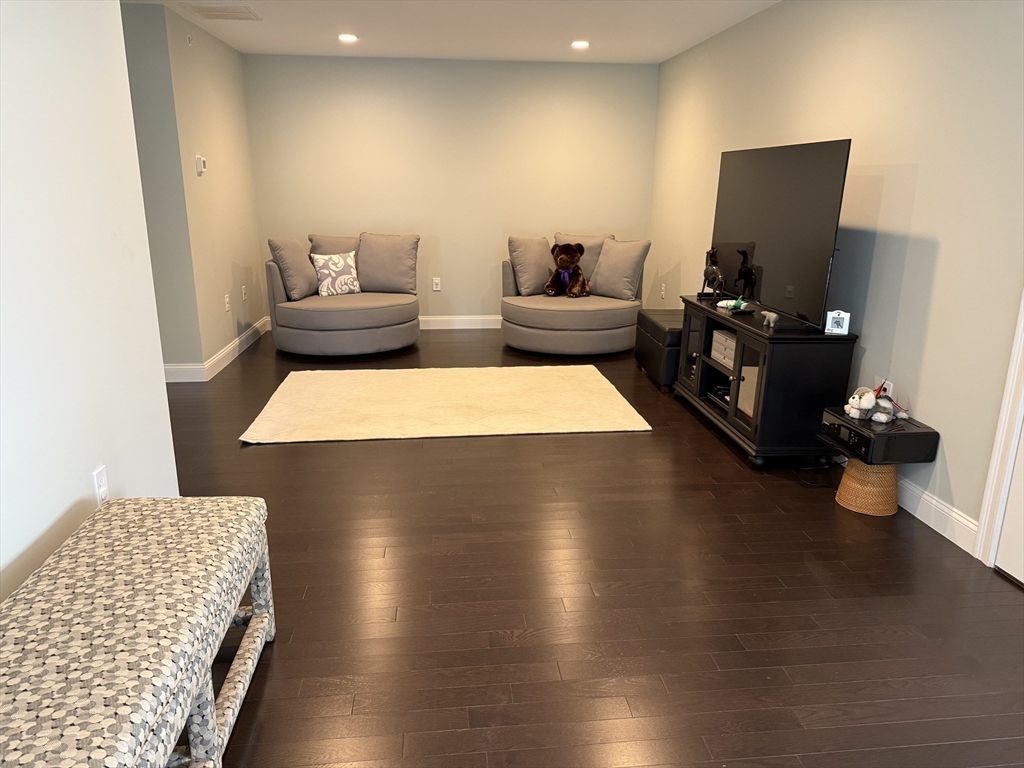 13 Birkdale Lane, Unit 13 Hopkinton, MA 01748 - Photo 17 of 27 a living room with furniture and a wooden floor