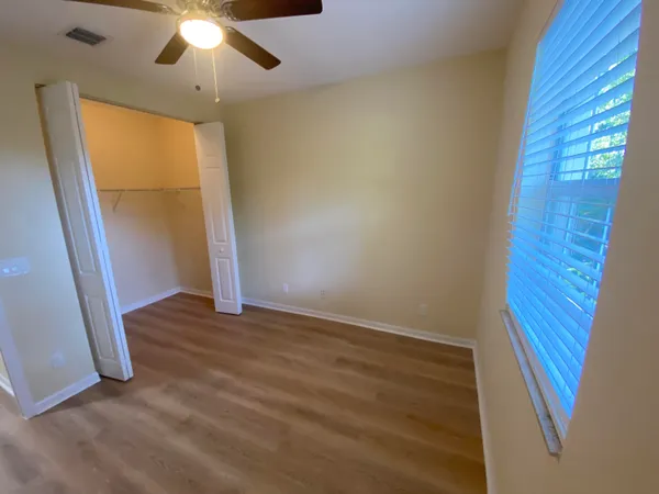 wooden floor in an empty room with a bathroom