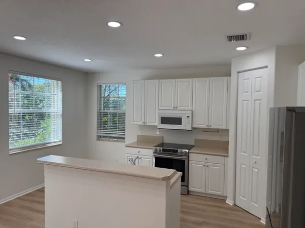 a kitchen with kitchen island granite countertop a stove sink and microwave
