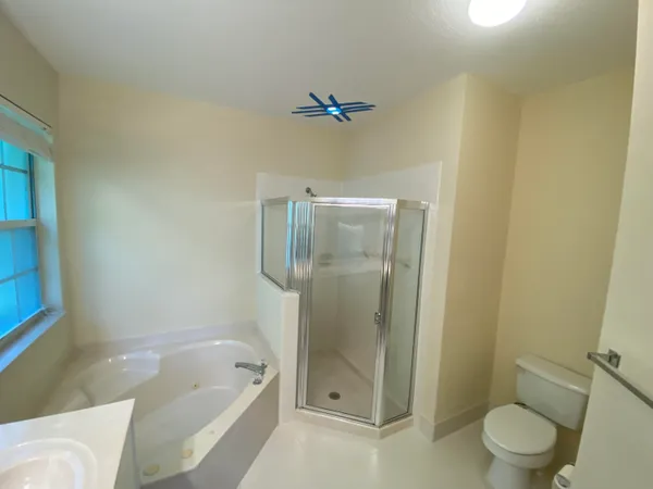 a bathroom with a shower a toilet and bathtub