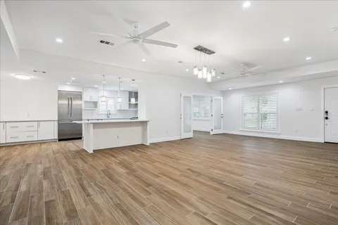 an empty room with wooden floor and windows