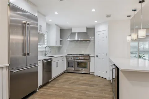 a kitchen with stainless steel appliances a refrigerator and a stove top oven