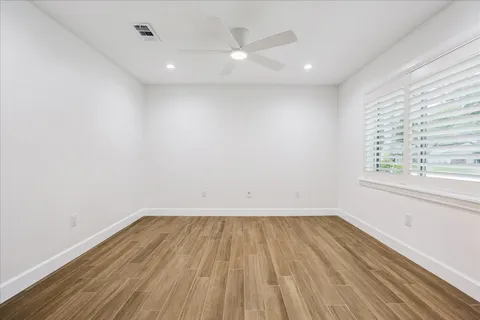 a large kitchen with stainless steel appliances kitchen island a large counter top and a wooden floor