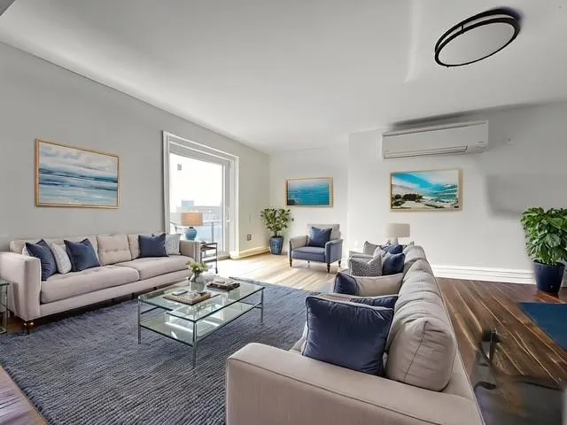 a living room with furniture a couch and a large window