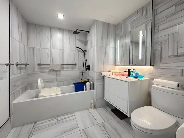 a bathroom with a tub a toilet and a shower