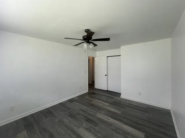 a view of room with wooden floor and ceiling fan