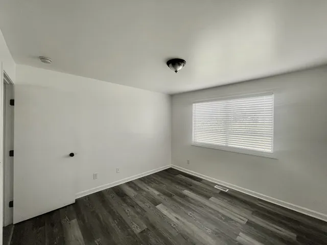 a view of a room that has wooden floor and windows in it