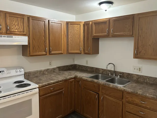 a kitchen with stainless steel appliances granite countertop a sink stove and cabinets