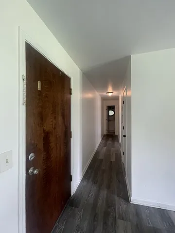 a view of a hallway with wooden floor