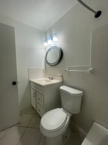 a bathroom with a toilet sink vanity and mirror