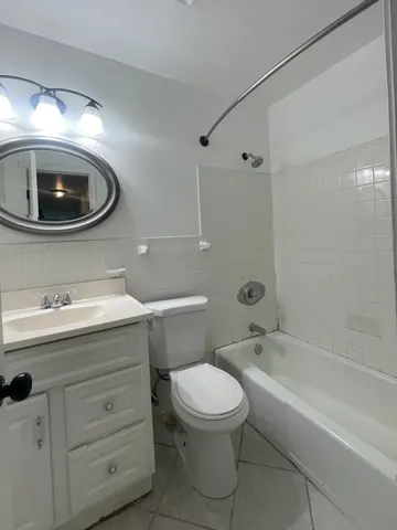 a bathroom with a toilet a sink a mirror and bathtub