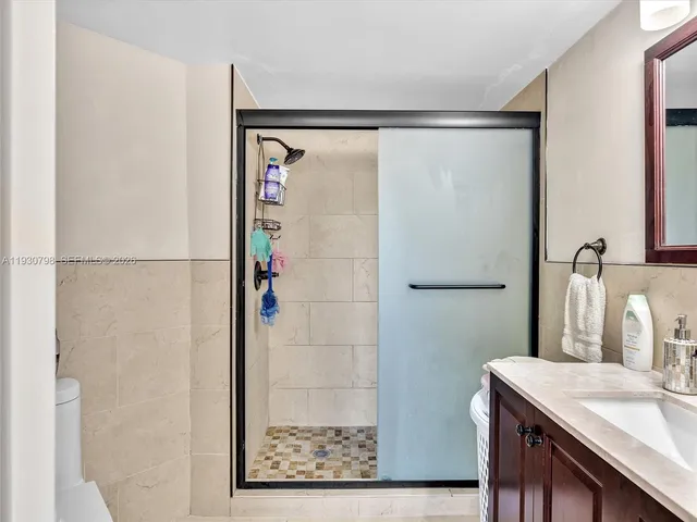 a bathroom with a granite countertop shower and a sink