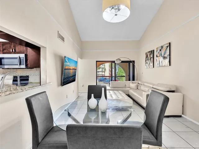 a view of a dining room with furniture a chandelier and wooden floor