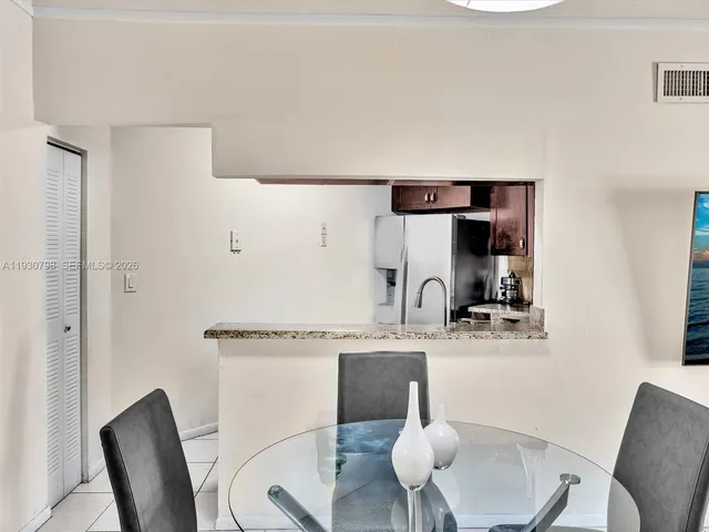 a kitchen with a table chairs and a refrigerator