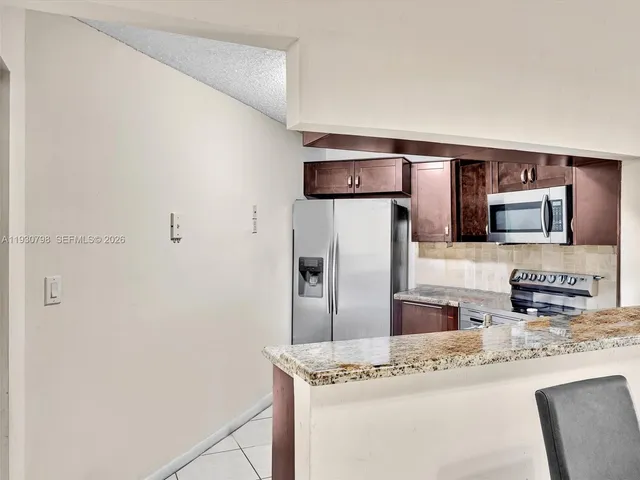 a kitchen with stainless steel appliances granite countertop a refrigerator and a sink