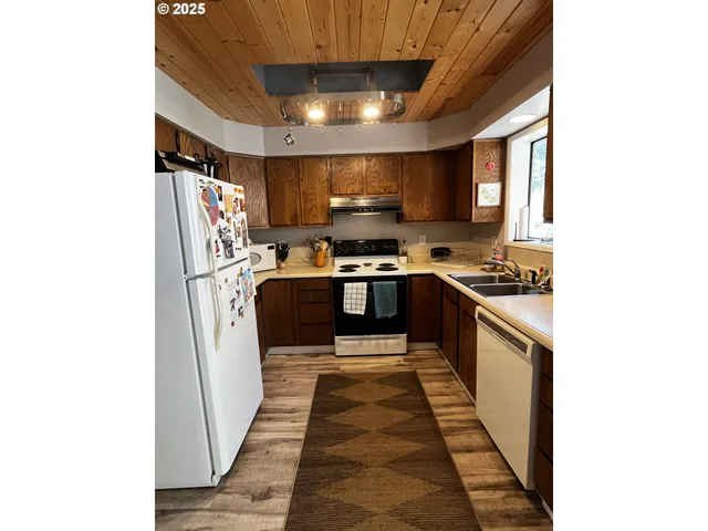 a kitchen with stainless steel appliances granite countertop a stove a sink and a refrigerator