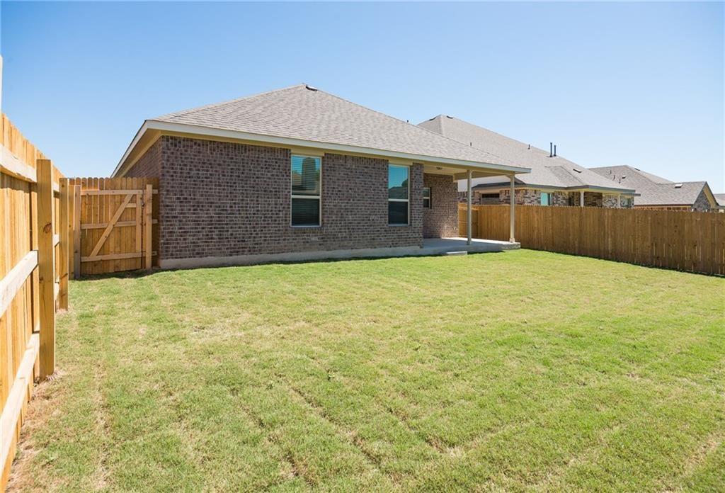 641 Schefer Street Leander, TX 78641 - Photo 17 of 17 Spacious backyard featuring a covered patio, brick exterior, full wood privacy fencing, and a side yard access gate