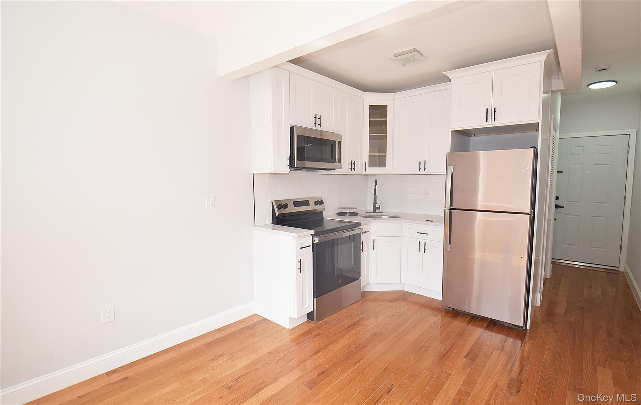 155-20 Tuskegee Airmen Way Queens, NY 11433 - Photo 3 of 13 a kitchen with a refrigerator stove and white cabinets
