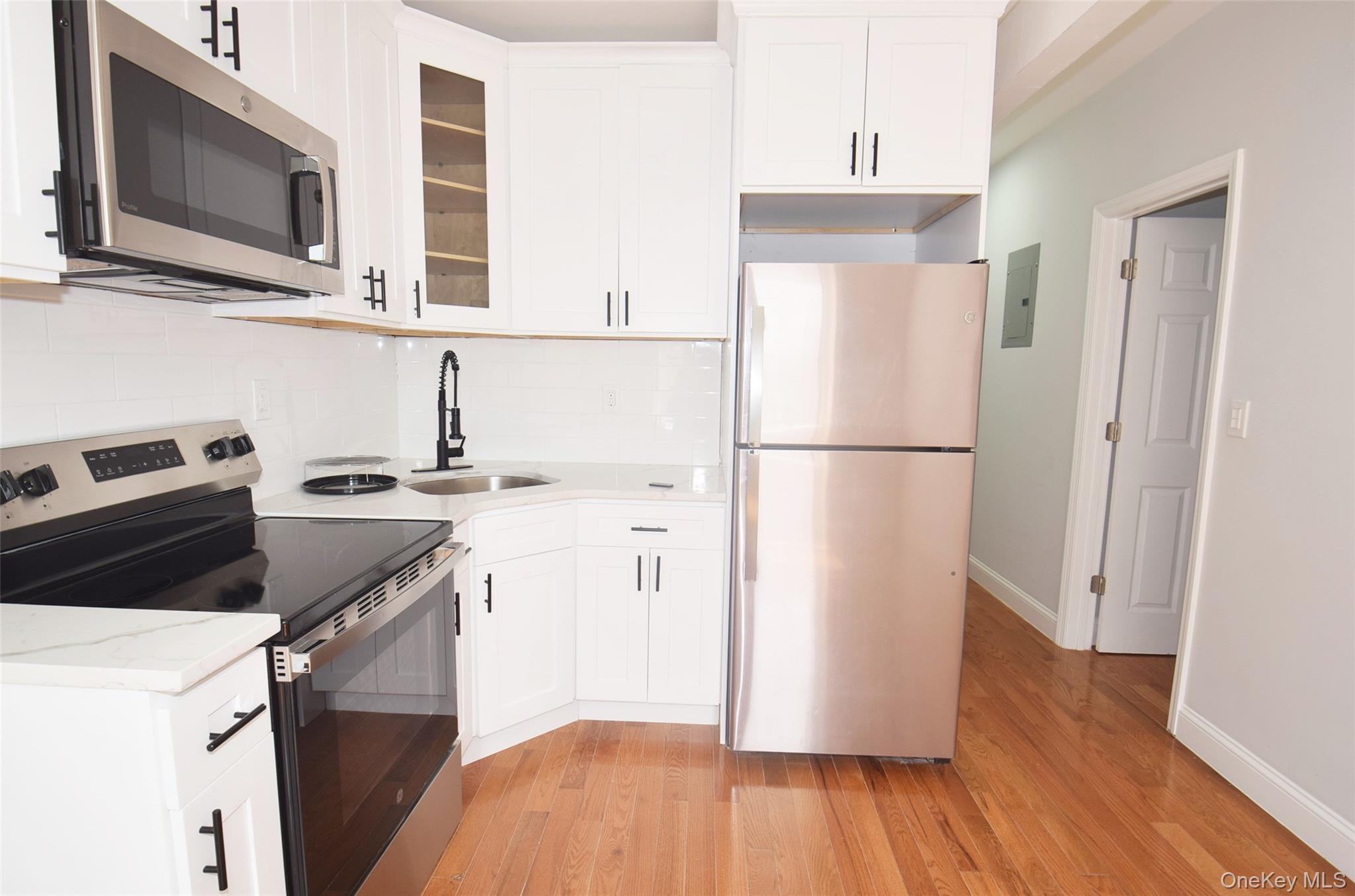 155-20 Tuskegee Airmen Way Queens, NY 11433 - Photo 4 of 13 a kitchen with a refrigerator stove and wooden floor