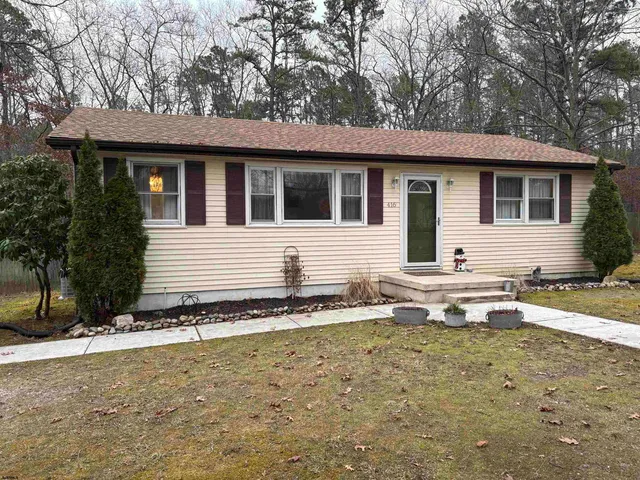 a view of a house with a yard and sitting area