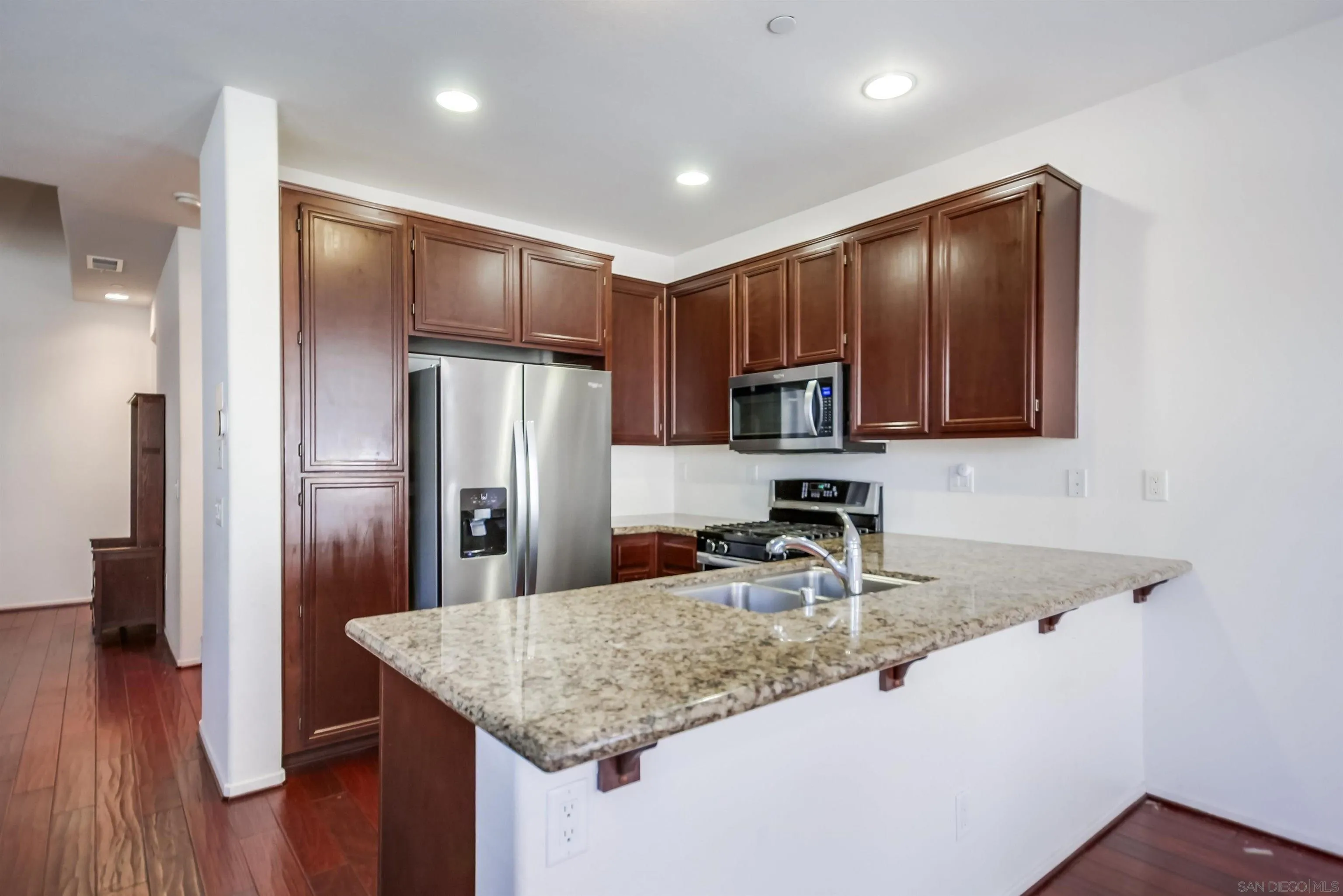 9810 Old Tree Lane Santee, CA 92071 - Photo 14 of 37 a kitchen with kitchen island granite countertop wooden cabinets a refrigerator and a sink