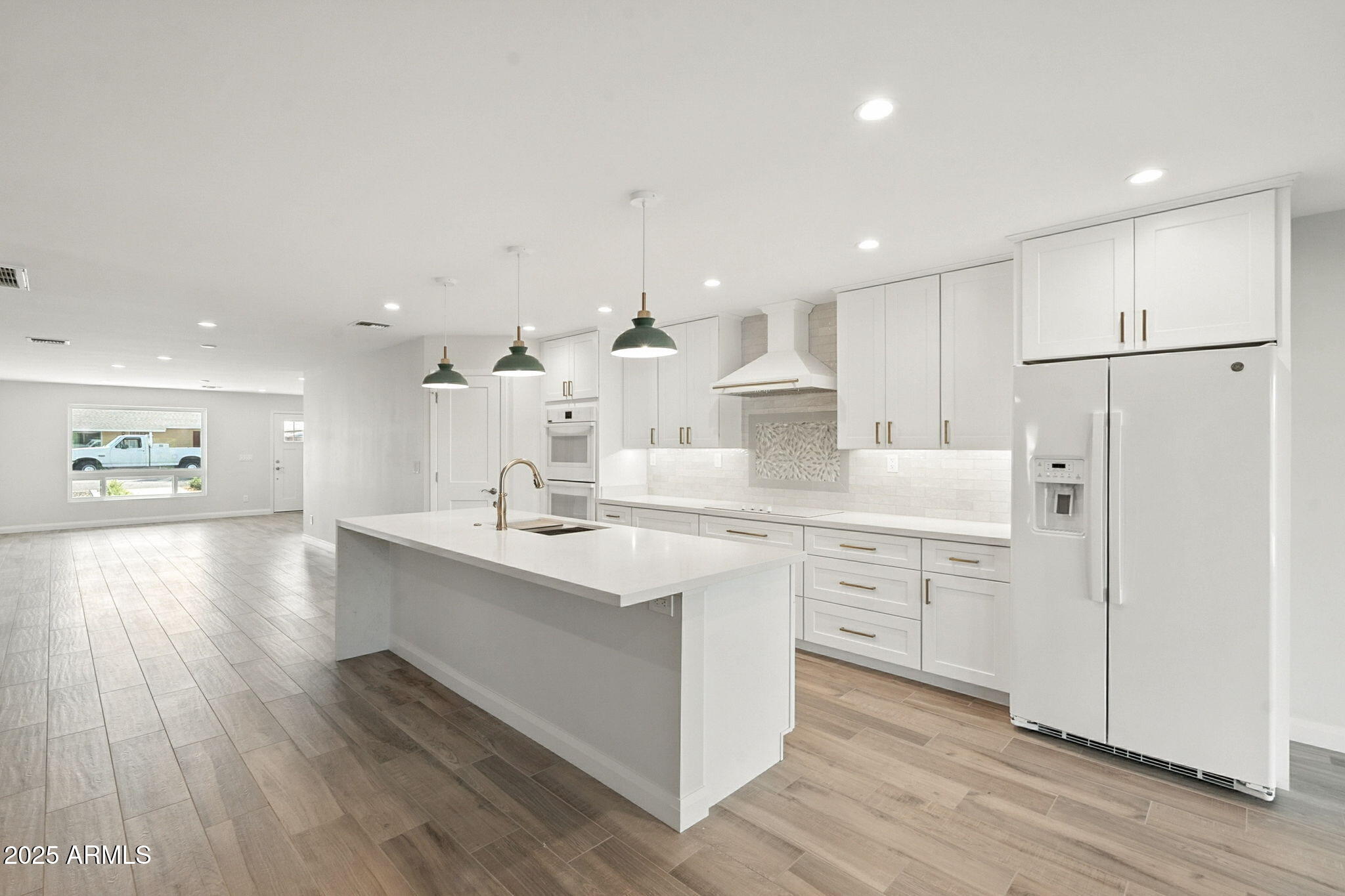 2814 North 51st Street Phoenix, AZ 85008 - Photo 10 of 50 a kitchen with white cabinets appliances and wooden floor