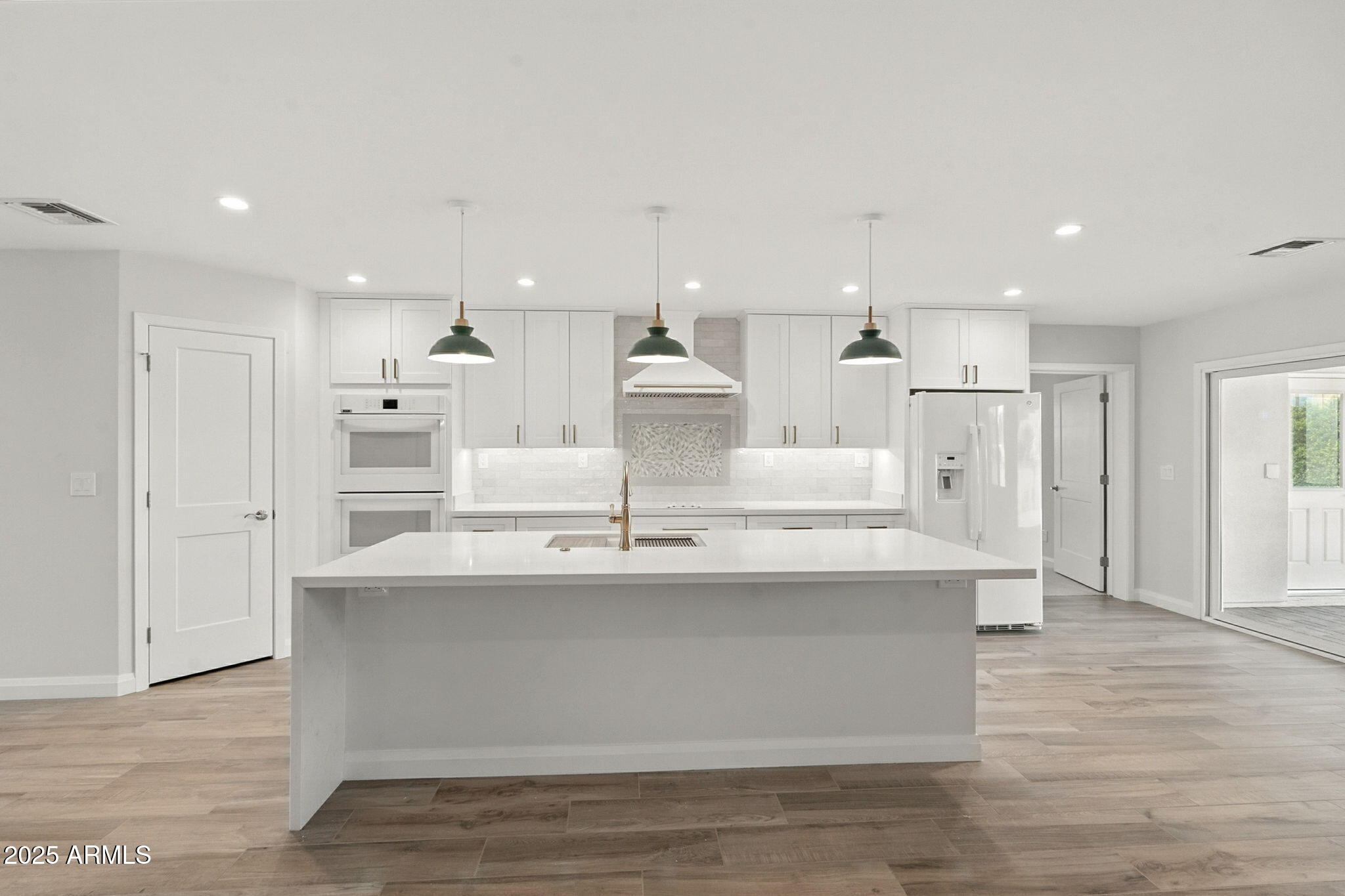 2814 North 51st Street Phoenix, AZ 85008 - Photo 11 of 50 a view of kitchen with white cabinets stainless steel appliances and wooden floor