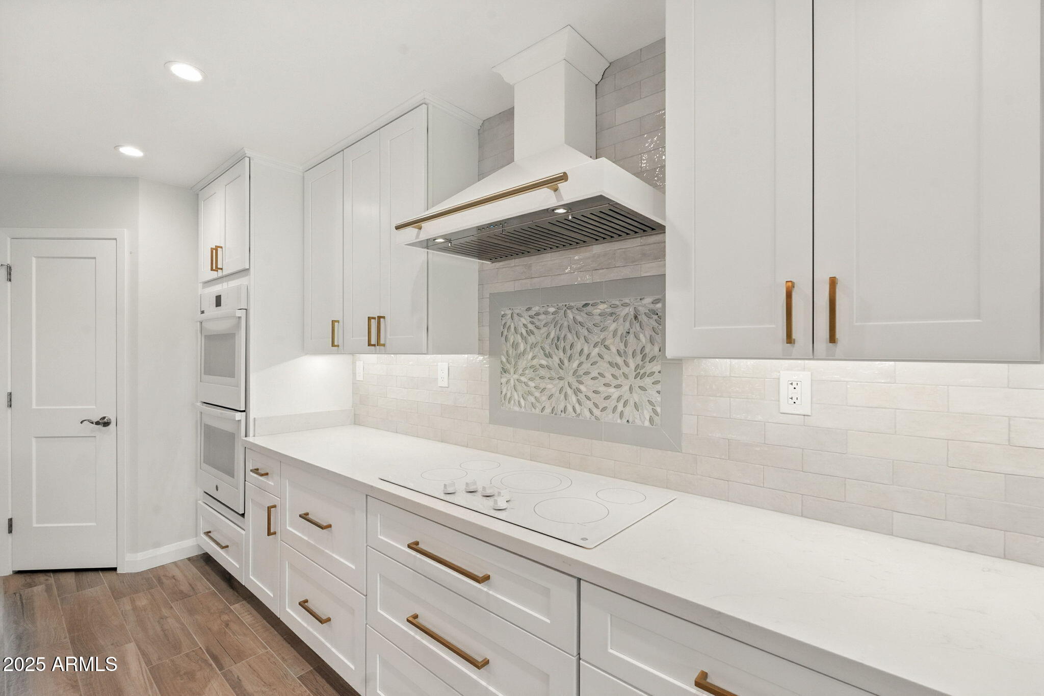 2814 North 51st Street Phoenix, AZ 85008 - Photo 14 of 50 a kitchen with stainless steel appliances white cabinets and wooden floor