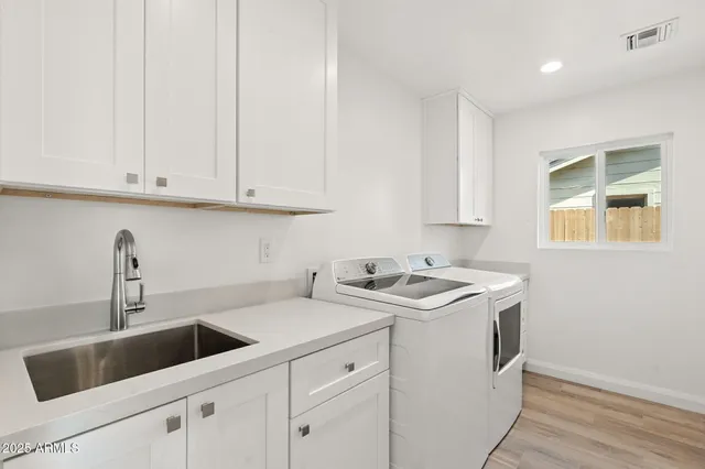 a view of a kitchen with sink and cabinets