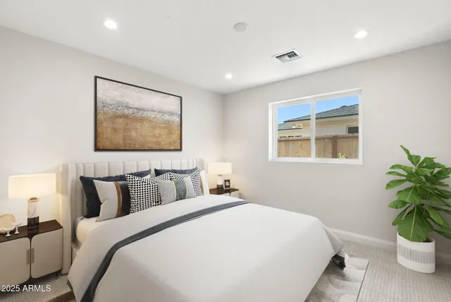 a bedroom with a large bed and a potted plant