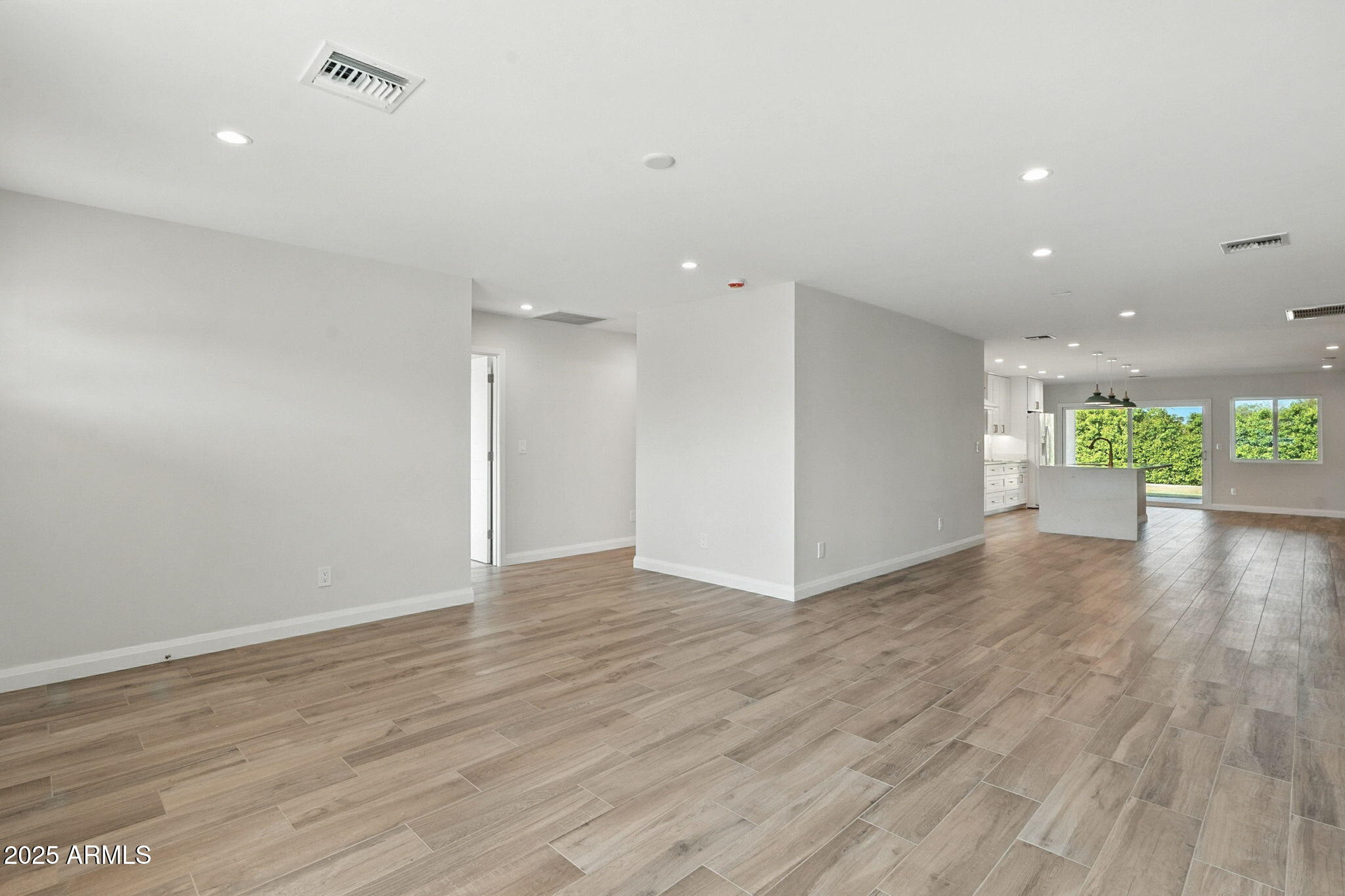 2814 North 51st Street Phoenix, AZ 85008 - Photo 5 of 50 a view of an empty room with wooden floor and a window