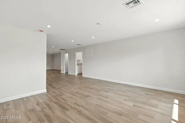 a view of an empty room with wooden floor